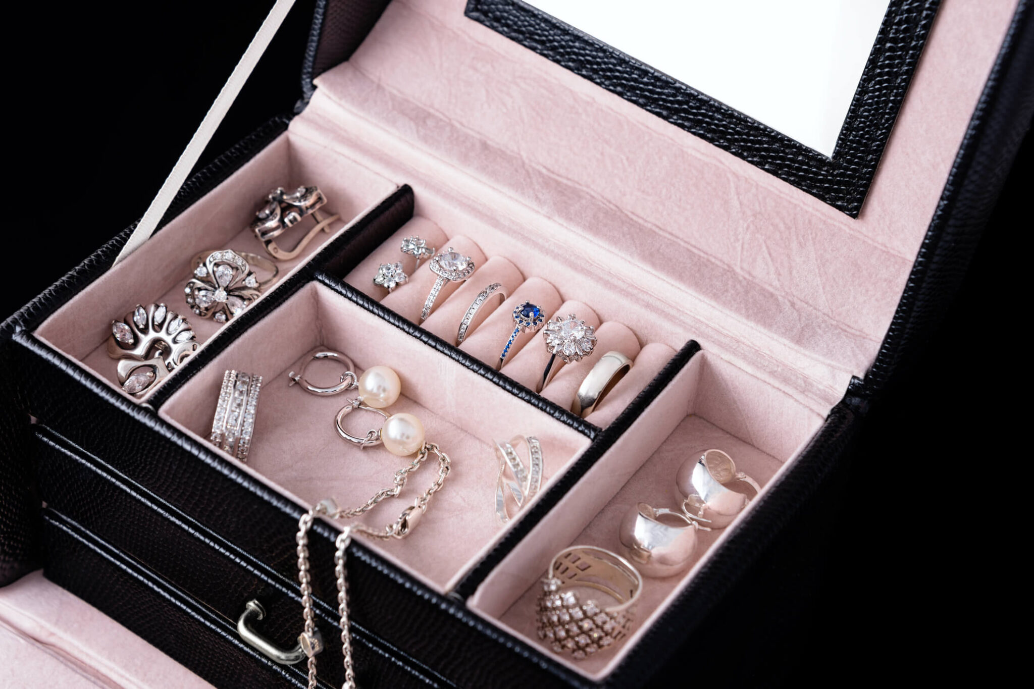 Jewelry box with white gold and silver rings, earrings and pendants with pearls