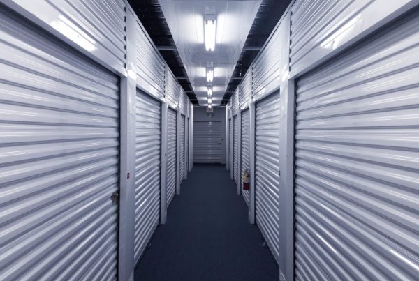 Indoor hallway with metal storage unit doors on each side.