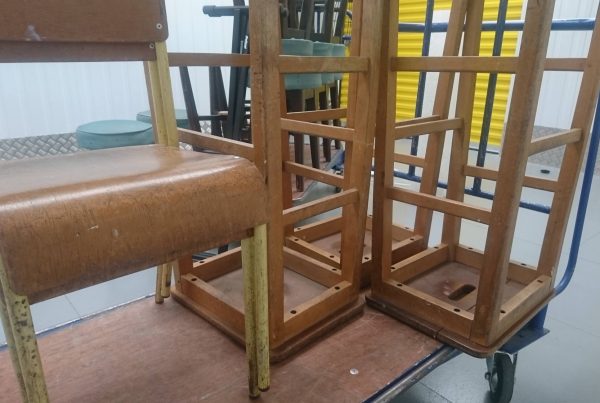 Vintage chairs and stools stacked up on a trolley ready for self storage.