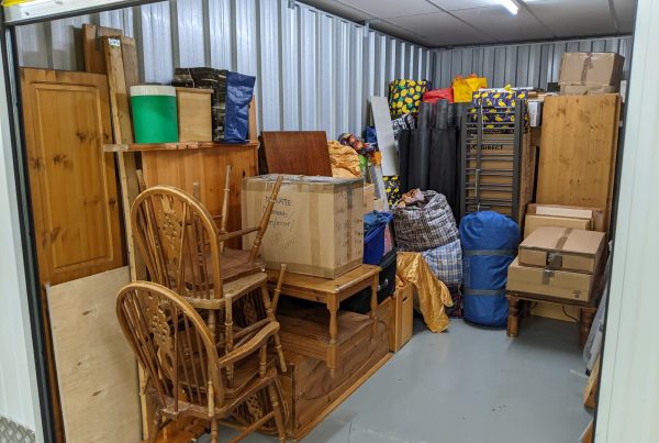 Self storage unit clearance packing furniture into room.